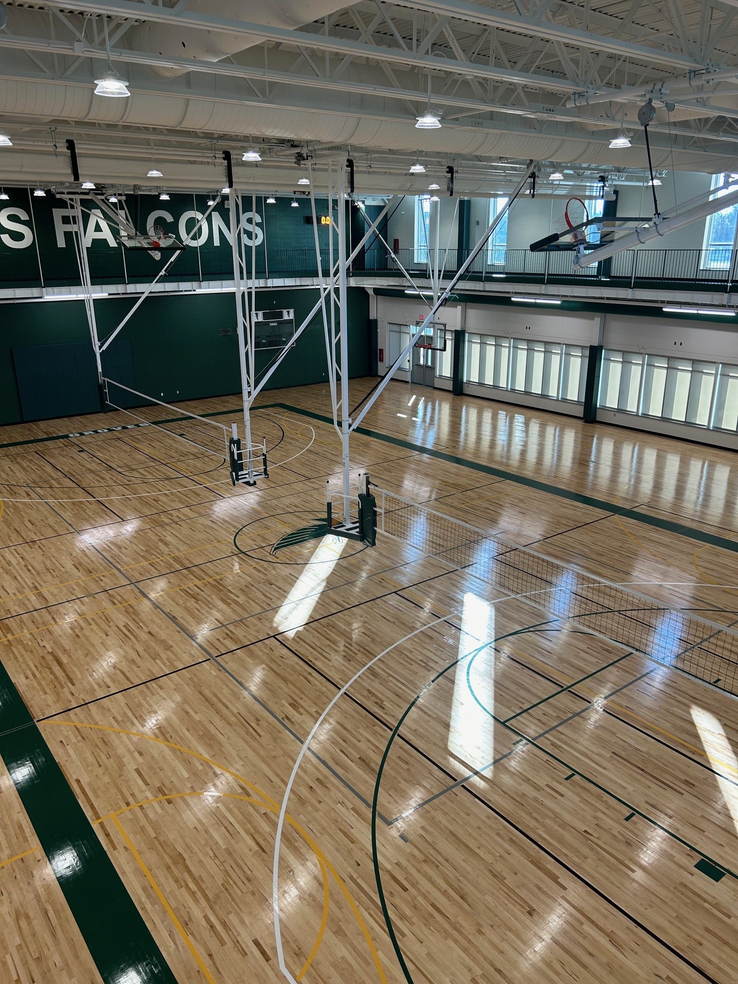 Volleyball standards & wall pads in multi-court gymnasium — Groves High School